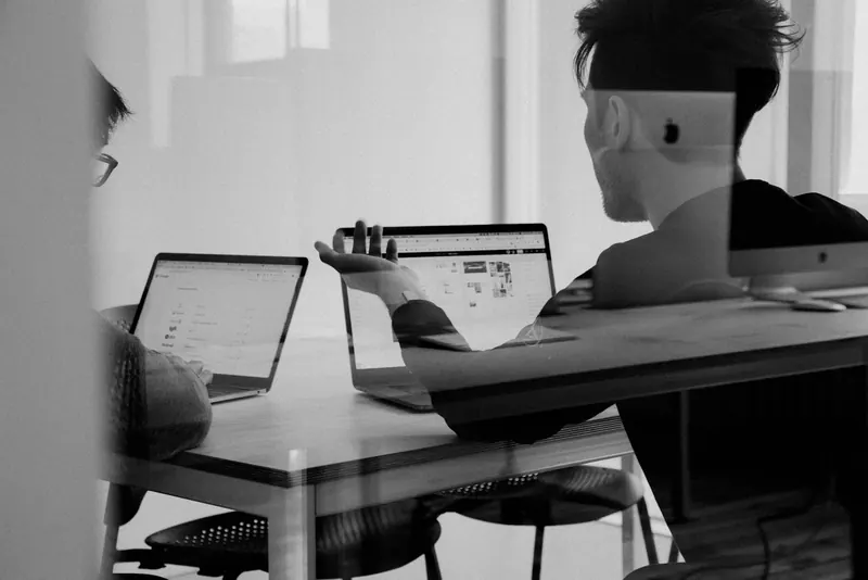 Team working on laptops with an AI assistant